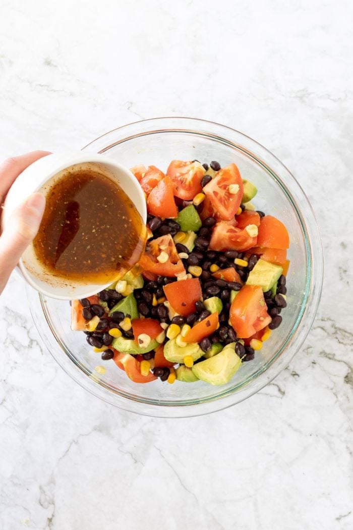 top down view of the dressing being poured onto the salad